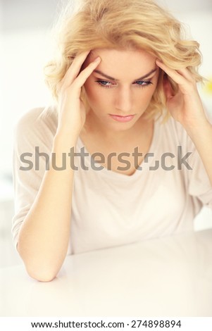 A picture of a young depressed woman with headache at home