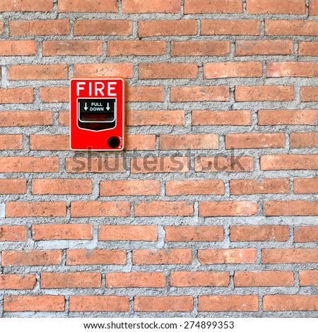 fire break glass alarm switch on brick wall background