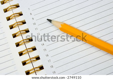 Notebook (organizer) and pencil, white paper, closeup