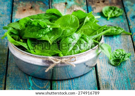 raw fresh organic spinach in a bowl on wooden rustic table Royalty-Free Stock Photo #274916789