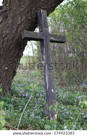 Old wooden cross under the tree