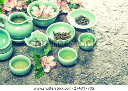 Teapot and cups with spring apple blossoms. Traditional chinese tea ceremony. Retro style toned picture.