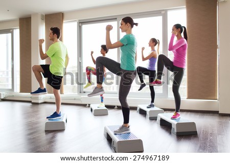 fitness, sport, training, aerobics and people concept - group of people working out with steppers in gym Royalty-Free Stock Photo #274967189
