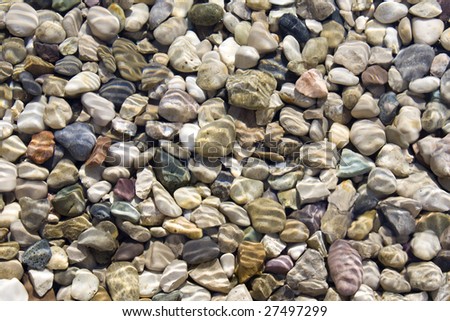 Small colorful pebbles under water on beach