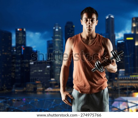 sport, fitness, weightlifting, bodybuilding and people concept - young man with dumbbell flexing biceps over night city background