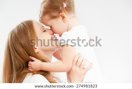 happy family mother and child baby daughter hugging and kissing