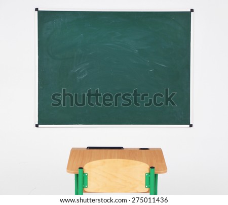 Blackboard and wooden desk with chair in class