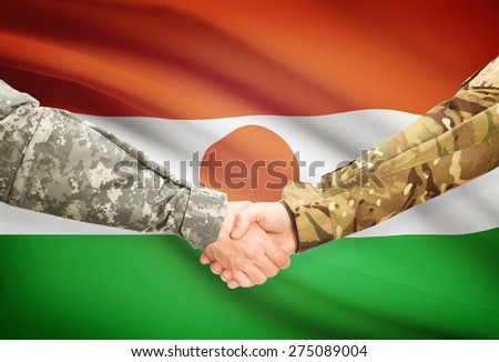 Soldiers shaking hands with flag on background - Niger
