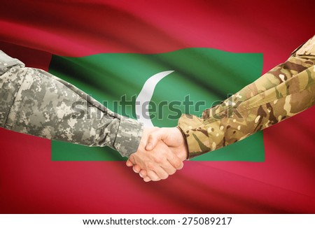 Soldiers shaking hands with flag on background - Maldives