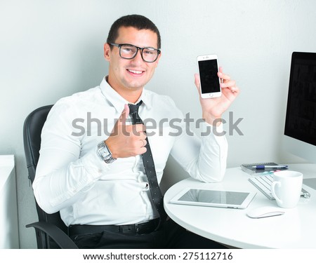 portrait of a successful businessman at office using mobile phone