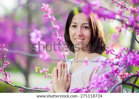 woman doing yoga on the background of a blooming garden, oriental cherry