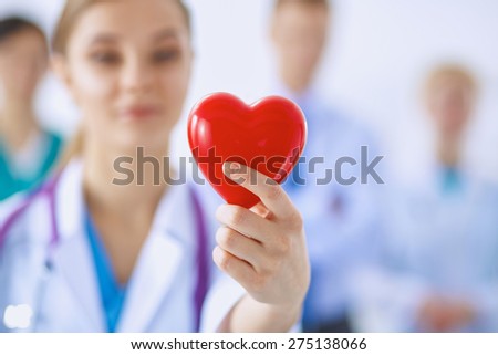 Female doctor with stethoscope holding heart .