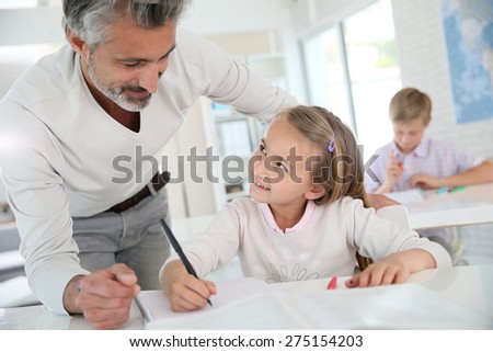 Teacher with schoolgirl in class