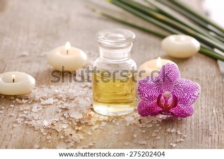 wooden background -orchid and candle, oil, green plant