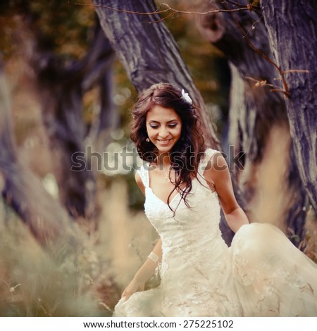 Wedding picture of happy bride in forest. Cross process vintage effect. 
