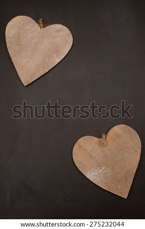 Two wooden heart shapes on a chalkboard