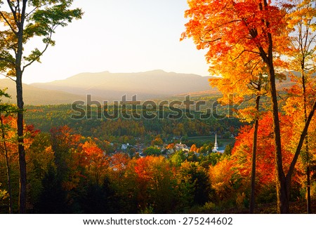 Overlooking Stowe Community Church sitting amongst the tranquil village of Stowe on a spectacular autumn sunset with Mt. Mansfield in the background, Stowe, VT, USA. Royalty-Free Stock Photo #275244602