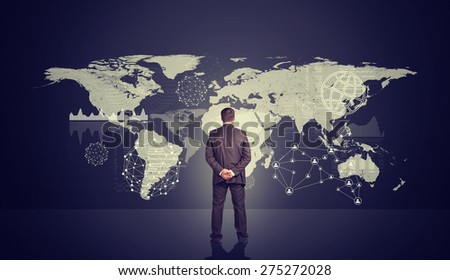 Businessman with hands behind back in front of violet holographic screen, back view. Virtual background