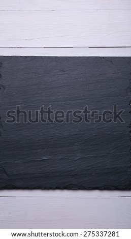 dark stone plate on wooden background