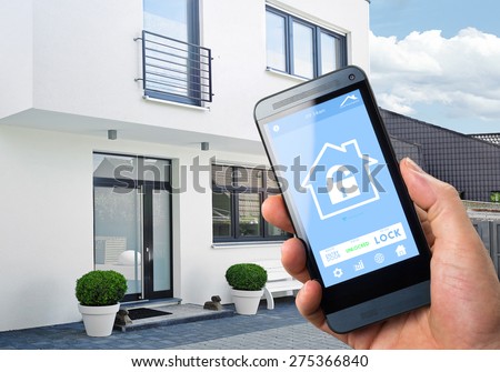 smart house, home automation, device with app icons. Man uses his smartphone with smarthome security app to unlock the door of his house. Royalty-Free Stock Photo #275366840