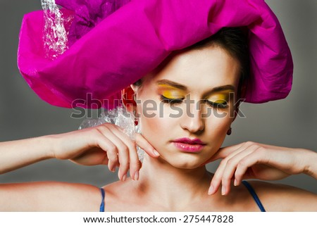 A girl with bright makeup in pink hat