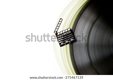 Movie clapper board on partially visible 35 mm film roll isolated on white background
