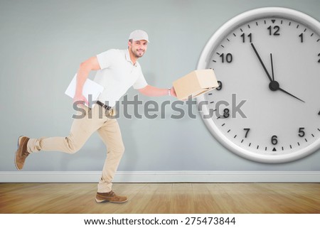 Delivery man with cardboard boxes running against room with wooden floor