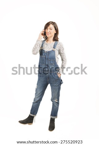 Full length portrait of a young woman in casual clothes, typing a text message on her cell phone. Connected anytime anywhere. Keep in touch