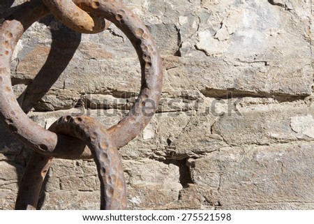 Old, big rusty iron chain on rock