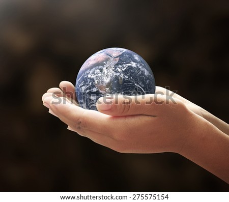 World environment day concept: Earth globe in human hands on nature background. Elements of this image furnished by NASA
