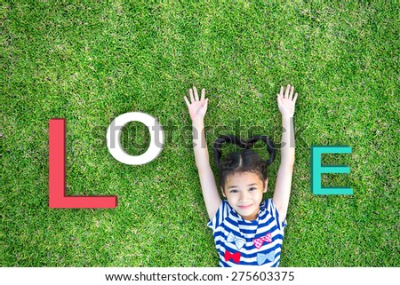 Love alphabet letter for happy Valentines' day and international children day concept with asian girl kid having fun in clean environment on green grass lawn Royalty-Free Stock Photo #275603375
