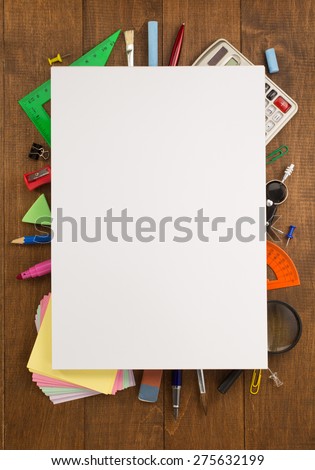 school supplies and paper on wooden background