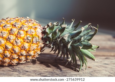 Fresh thai pineapple on a rustic wooden background. Soft focus artistic fruit photo with vintage toning.
