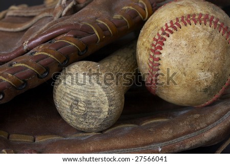 a macro picture of a baseball, glove, and bat