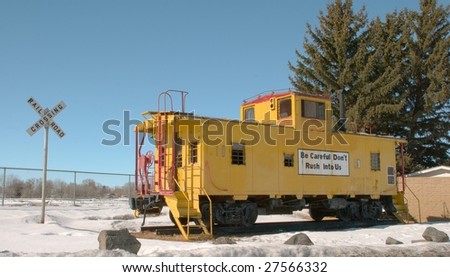 A caboose sits on display in a wintry park.