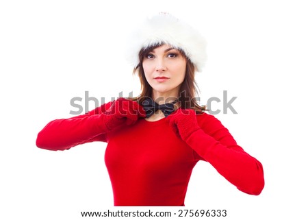 Portrait of joyful pretty adult woman in red santa claus hat and bow tie isolated on white background. Beautiful girl looking happy and excited. Happy Christmas and New Year holidays full of fun.