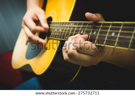 Close up hands playing acoustic guitar