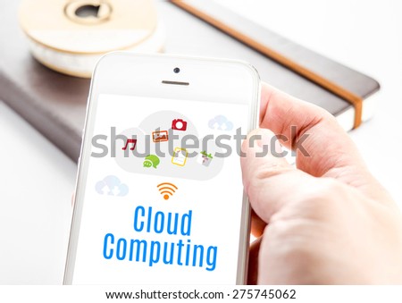 Close up hand holding smart phone with Cloud Computing word and icons with notebook at background, Mobile technology concept