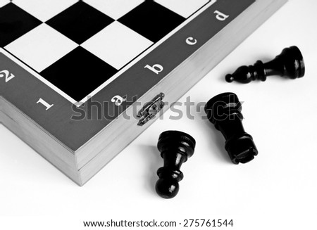 Chess pieces on a chessboard on a light background. Black - white image.