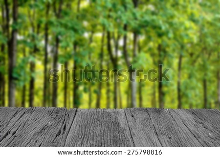 Defocus and blur image of old wood and beautiful green forest for background usage
