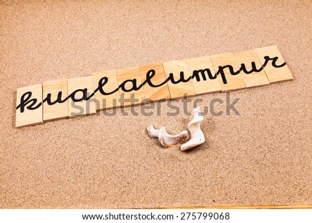 Words formed from small pieces of wood containing a sun and beach tourist destination, kualalumpur