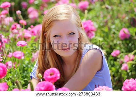 Teenage girl in pink flowers on the field. Summer concept