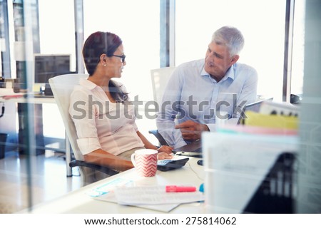Office colleagues talking at work Royalty-Free Stock Photo #275814062