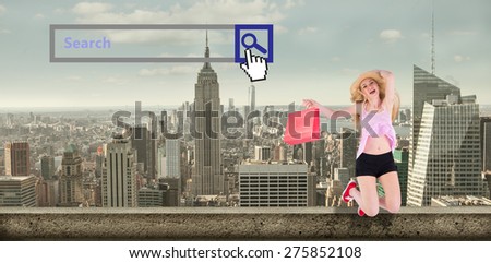 Pretty young blonde holding shopping bags against large city
