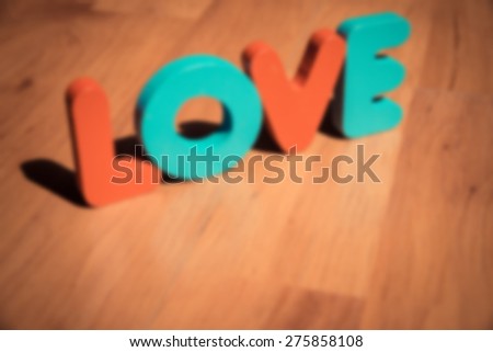Wooden word LOVE on laminate floor in bright style in Blur style