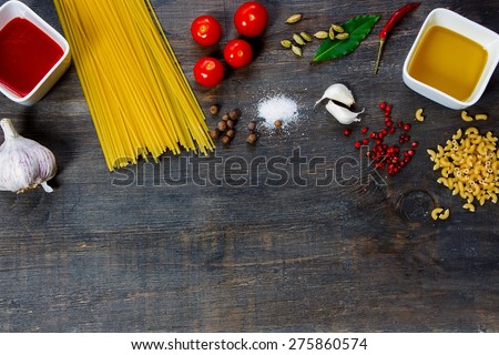 Pasta and ingredients on dark wooden background with copy space. Top view. Vegetarian food, health or cooking concept.