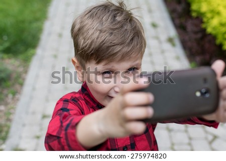 Little kid taking a selfie with cell phone