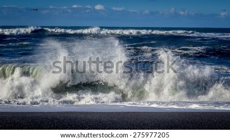 A big wave crashes on the beach.