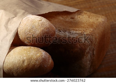 Loafs of white and rye bread in paper packet closeup, horizontal picture
