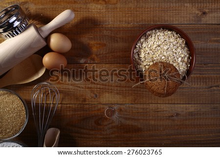 Collection of ingredients and appliances for making pastry with oatcakes brown sugar and oatmeal on wooden table top copyspace, horizontal picture